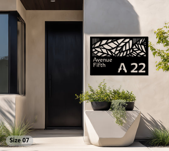 Textured surface details highlight the geometric leaf cutouts of this decorative metal wall decor address sign, a modern house number plaque.