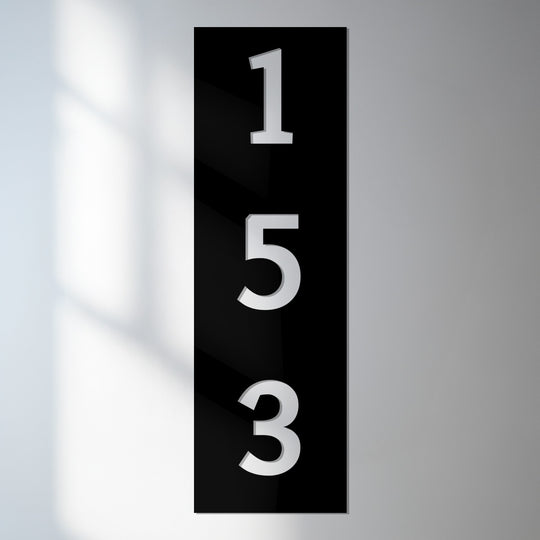 Bold, vertical metal house number sign displaying '153' presents a modern address plaque with decoration wall art highlighting its typographic impact.