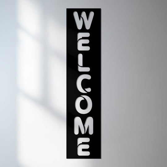 Layers of shadow and light enhance the depth of this modern welcome sign crafted as decorative metal art, a striking vertical display for any entryway.