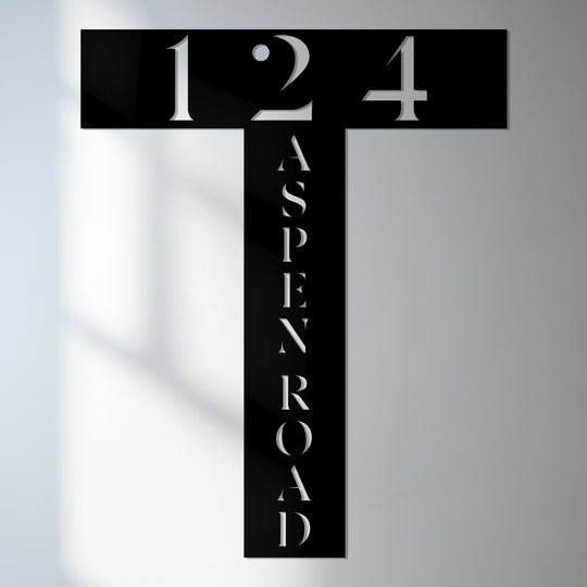 Cool color temperature emphasizes the crisp white lettering and cutouts in this decorative metal art sign displaying the address number and street name.