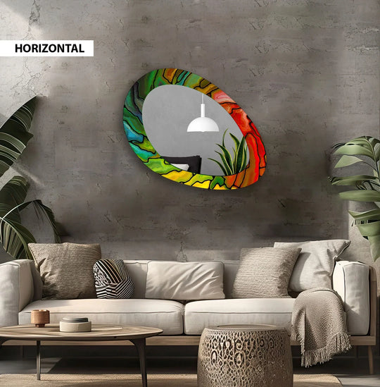 The colorful, asymmetrical edge defines this red and green oval wall mirror, creating a unique home decor accent piece.