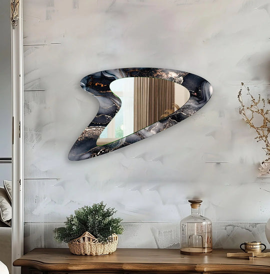 Asymmetrical grey watercolor modern wall mirrors artfully reflecting a dresser with a potted plant and clear bottle, commanding attention as the loudest element in the room.