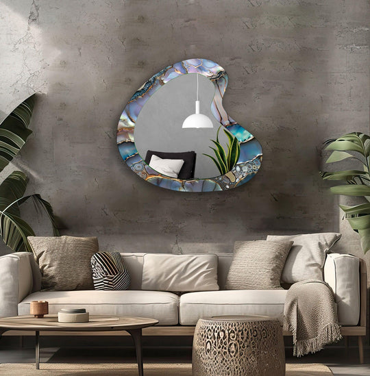Asymmetric mirror with an irregular abstract purple blue and gold design reflecting a white lamp and green plant a unique artistic wall mirror