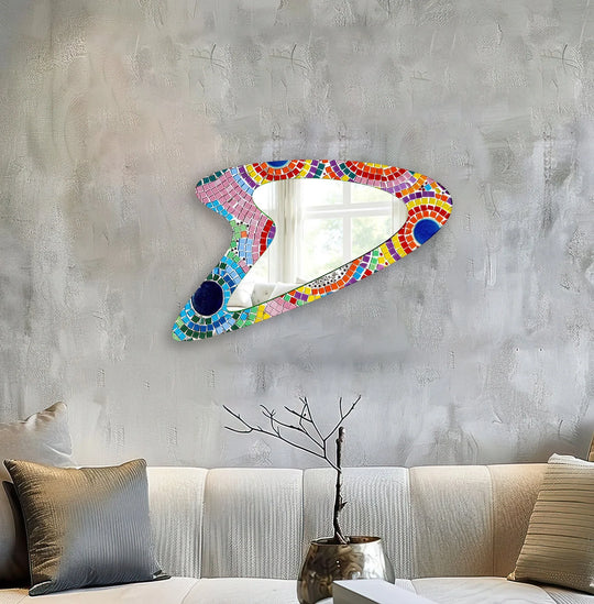 The striking transitions of color define this pink mosaic asymmetrical glass wall mirror, bringing a touch of home decor to any space.