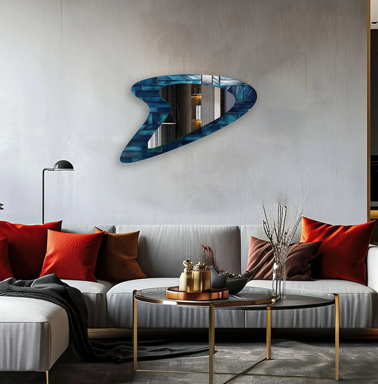 An asymmetric mirror in vivid blue abstract design showcases an irregular shape and glossy finish on a light grey wall making an artistic statement