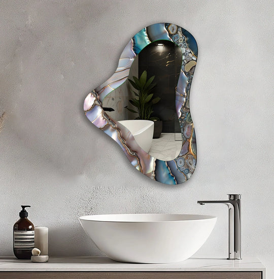 Subtle light and shadow play across this asymmetrical decorative mirror, accentuating the purple hues within its unique, organic glass frame, creating a captivating focal point.
