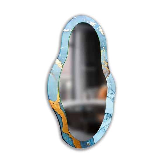 Soft, dreamy blues and gold accents define this artful framed wall mirror, a decorative accent that elevates any space with its asymmetrical charm.