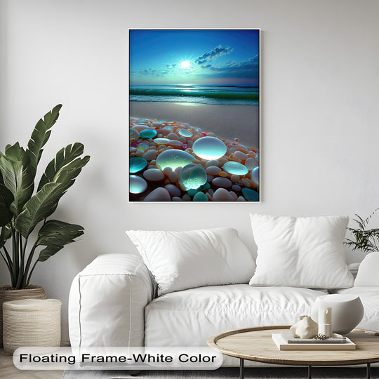The detailed surface texture highlights the smooth, luminous pebbles, fine beach sand, and the gentle ocean waves on this vibrant framed canvas.