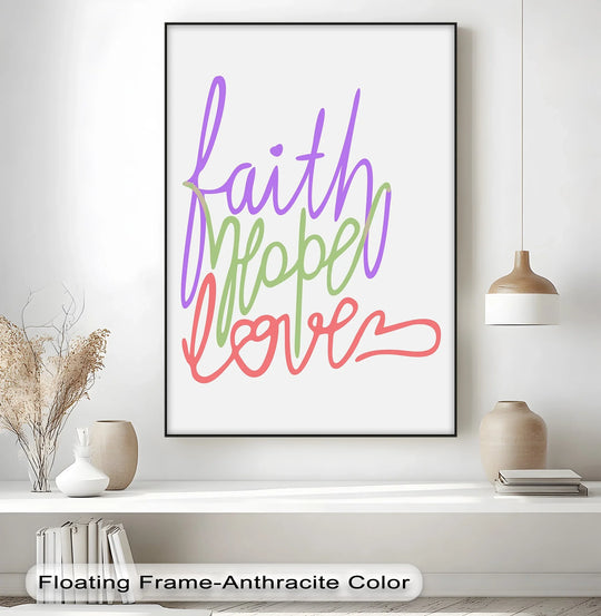 Subtle light defines the edges of this framed canvas artwork print displaying 'Faith, Hope, Love' in vibrant, inspirational hues, casting soft shadows on the shelf.