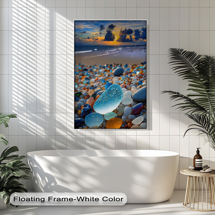 The organic forms of smooth sea glass and polished beach pebbles shimmer on this framed canvas, showcasing a vibrant coastal sunset.