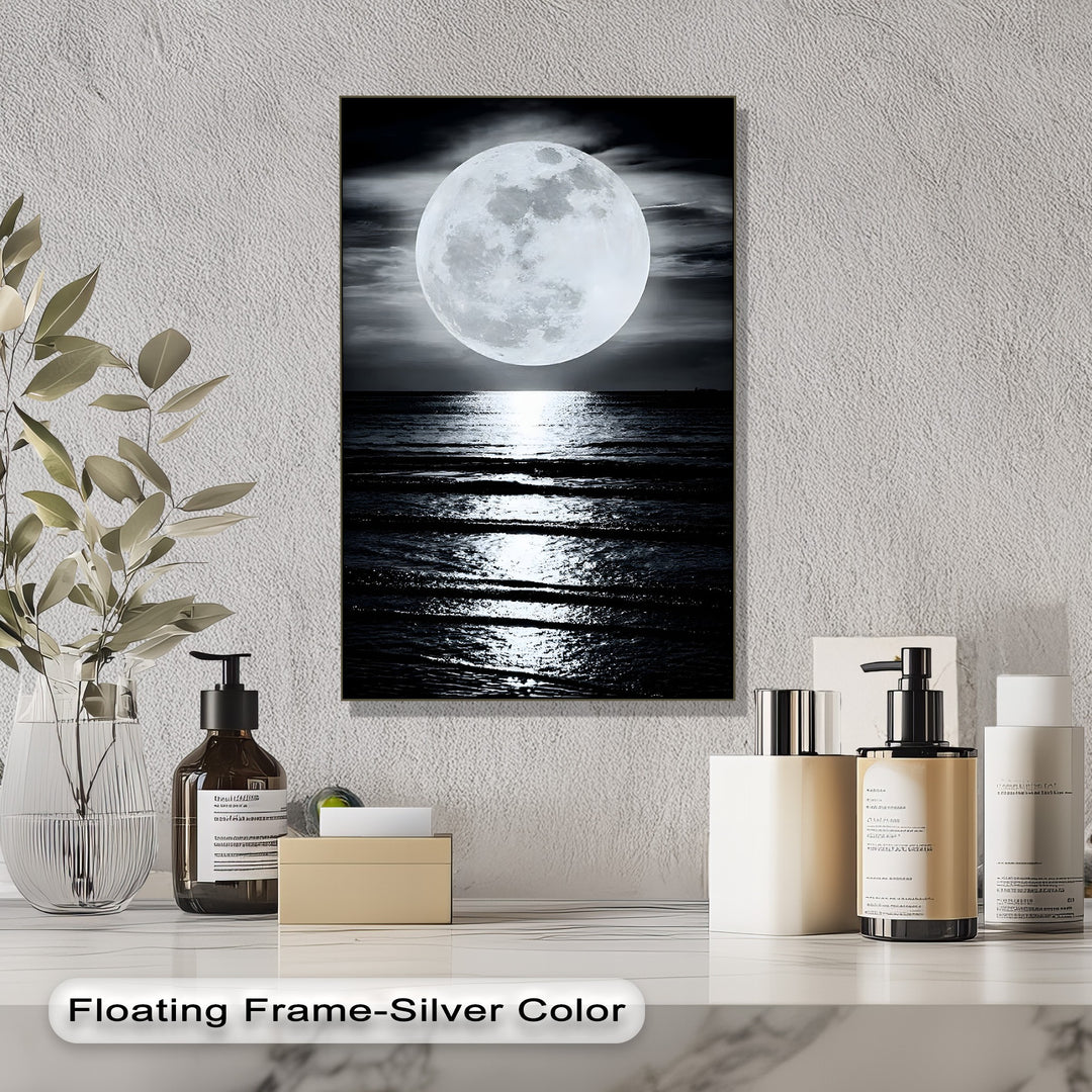 The dramatic color contrast of the glowing full moon and its shimmering reflection on the dark ocean creates a captivating framed canvas.