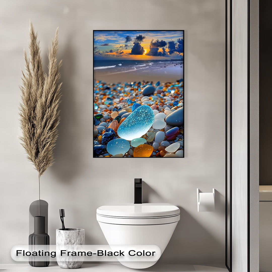 The sleek black border of this framed canvas highlights a vibrant coastal sunset over ocean waves and an array of colorful sea glass pebbles.