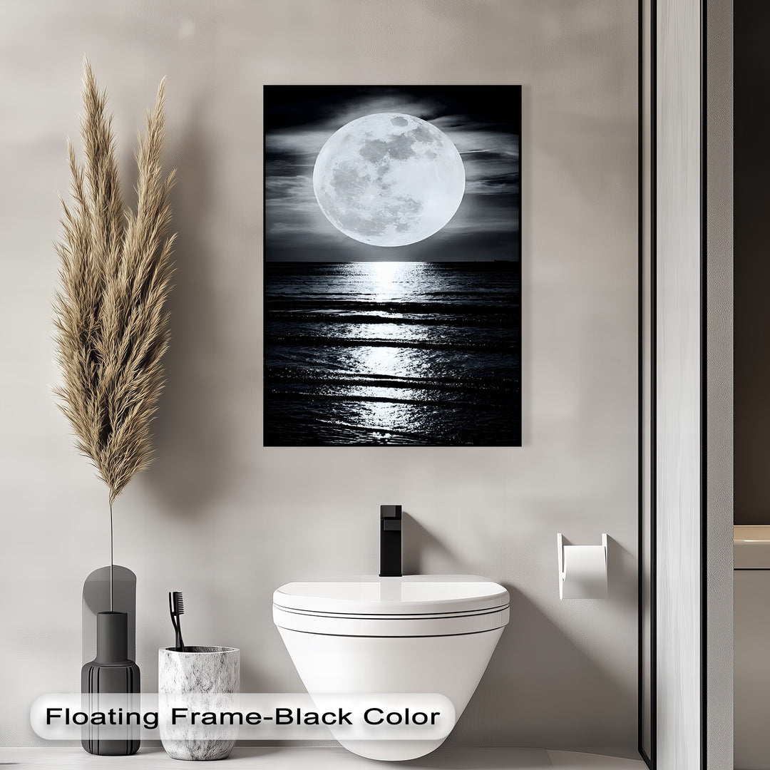 The desaturated color saturation of this best canvas prints showcases a glowing full moon reflecting on dark ocean waters, a serene seascape.