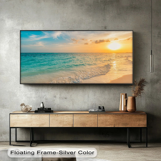 Transitioning from a clear cerulean sky to a fiery sunset, this landscape canvas artwork showcases the gradation of colors in the serene ocean canvas print.