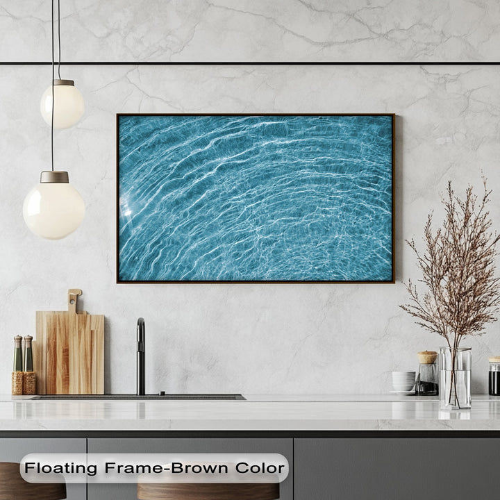 Highlighting incredible depth and layers, the abstract blue water ripple canvas wall decor features shimmering light over the undulating surface.