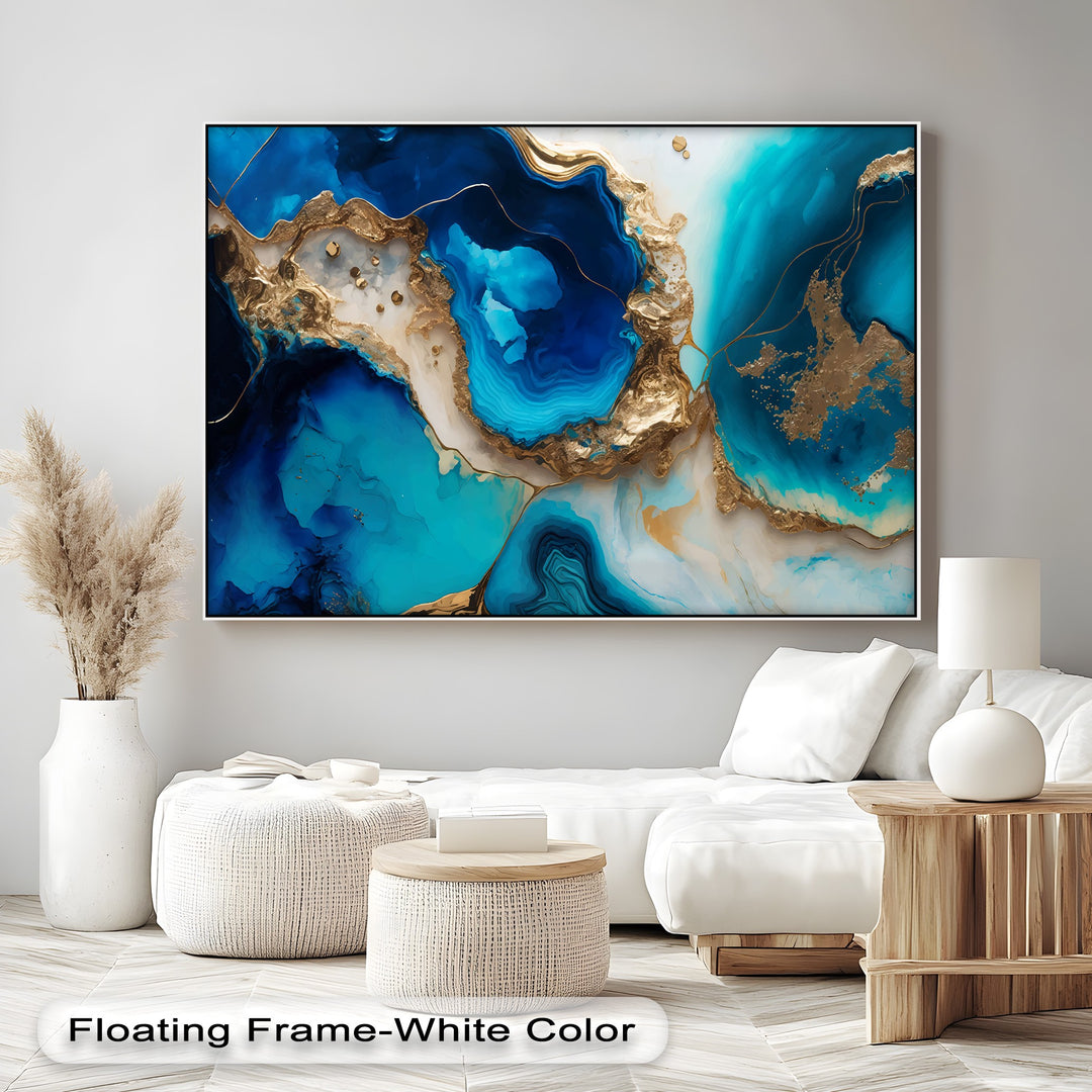 The elegant white floating frame highlights the vibrant blue and gold agate abstract canvas painting, perfectly bordering the luxury ocean wall art.