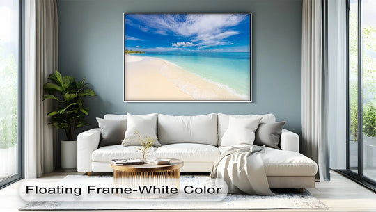 Clean, white borders frame this square, landscape canvas art prints, showcasing a tropical beach with crystal waters above a modern white sofa.