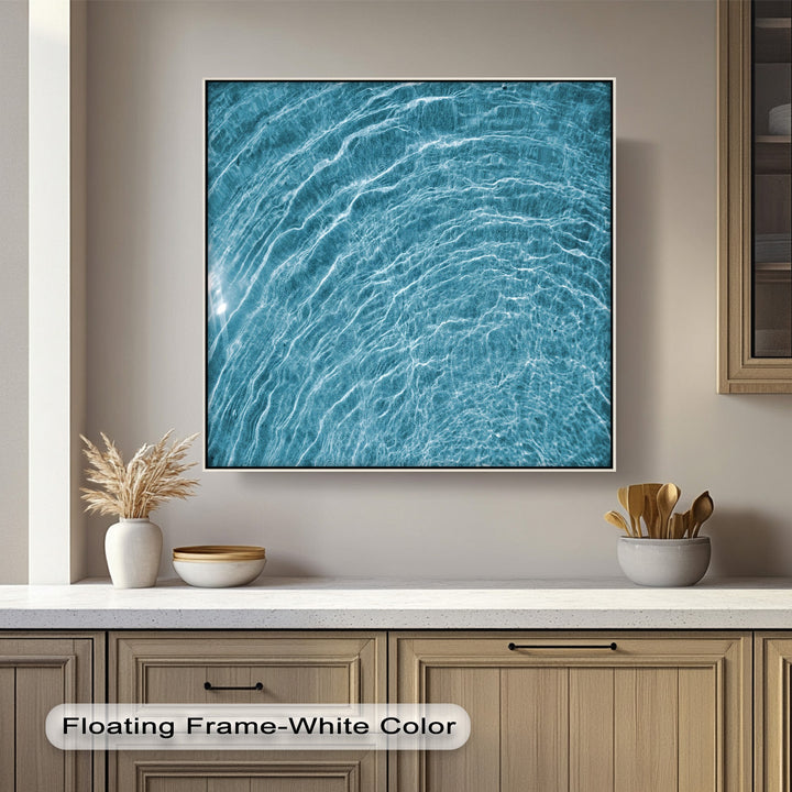 The strong color contrast between the vibrant turquoise water ripples and brilliant white highlights defines this abstract canvas wall decor.