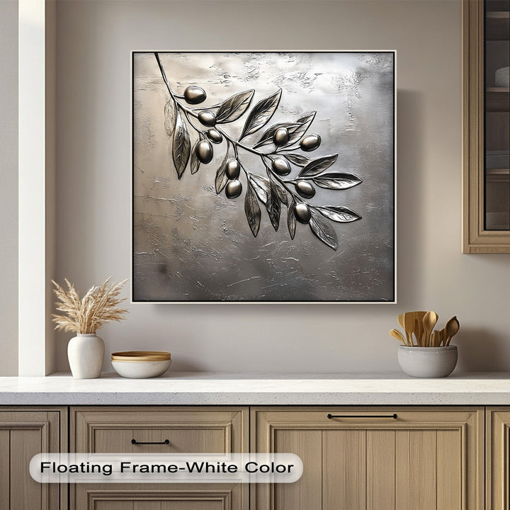 The organic forms of a metallic silver olive branch with sculpted leaves and olives are beautifully depicted on this elegant botanical hanging canvas print.