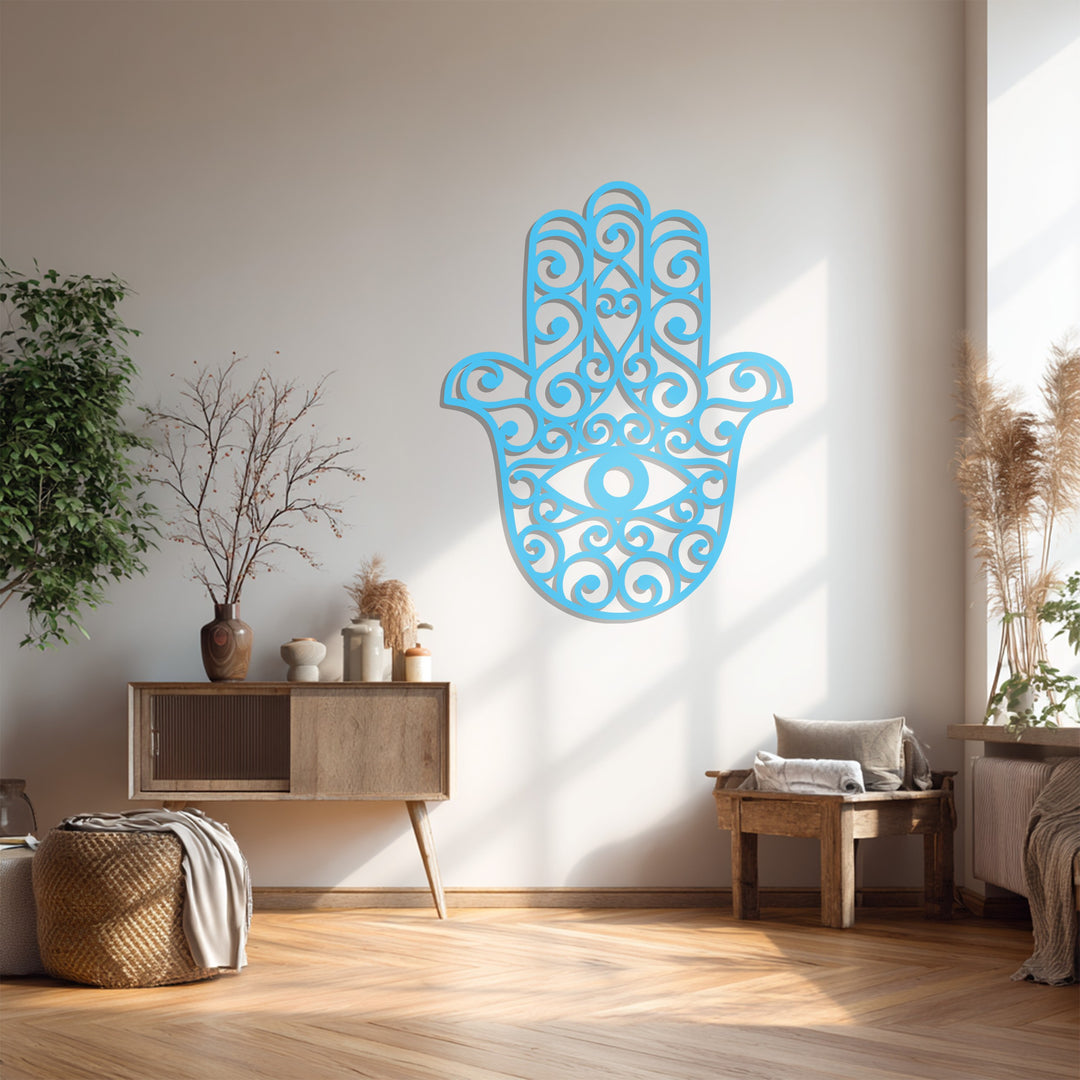 Brightest area highlights the cut-out details of this azure Hamsa hand design, a piece of metal artwork casting a shadow on the wall.