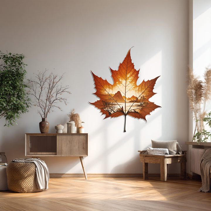 Warm amber tones highlight the intricate details of the metal artwork, creating a cozy autumn-themed focal point with this maple leaf nature landscape metal artwork.