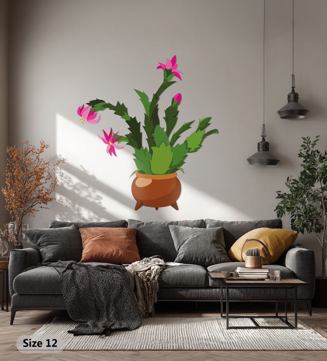 Highlights and lowlights enhance the decorative metal art depicting a blooming pink cactus, casting dramatic shadows against the wall, creating a bold and colorful botanical piece.