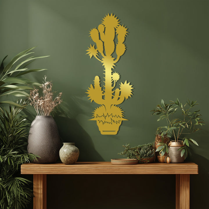 Highlighting the brightest area, a gold-toned spiky desert cactus metal artwork stands out against the sage wall, creating modern botanical wall decor.
