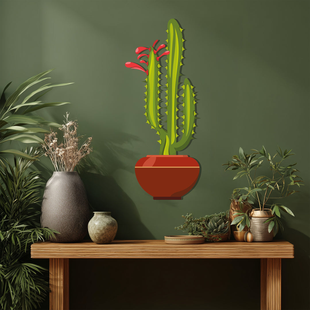 Examining the realistic detail, this metal art for wall piece displays a twin column cactus with red blossoms in a rust colored pot, presented on a wooden table.