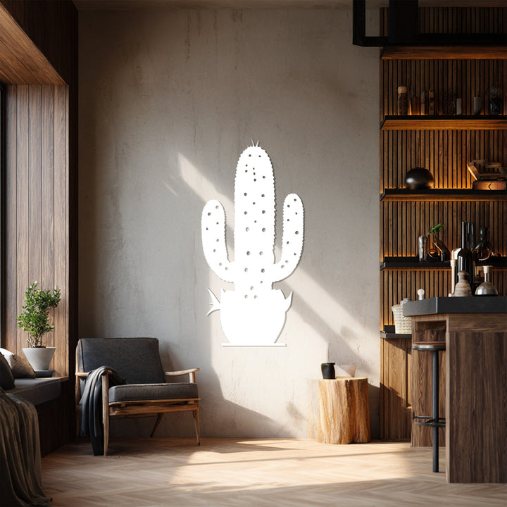 The stillness of the scene focuses on the decoration wall art, a white metal cactus wall decor casting a soft shadow on the neutral wall behind a wooden chair.