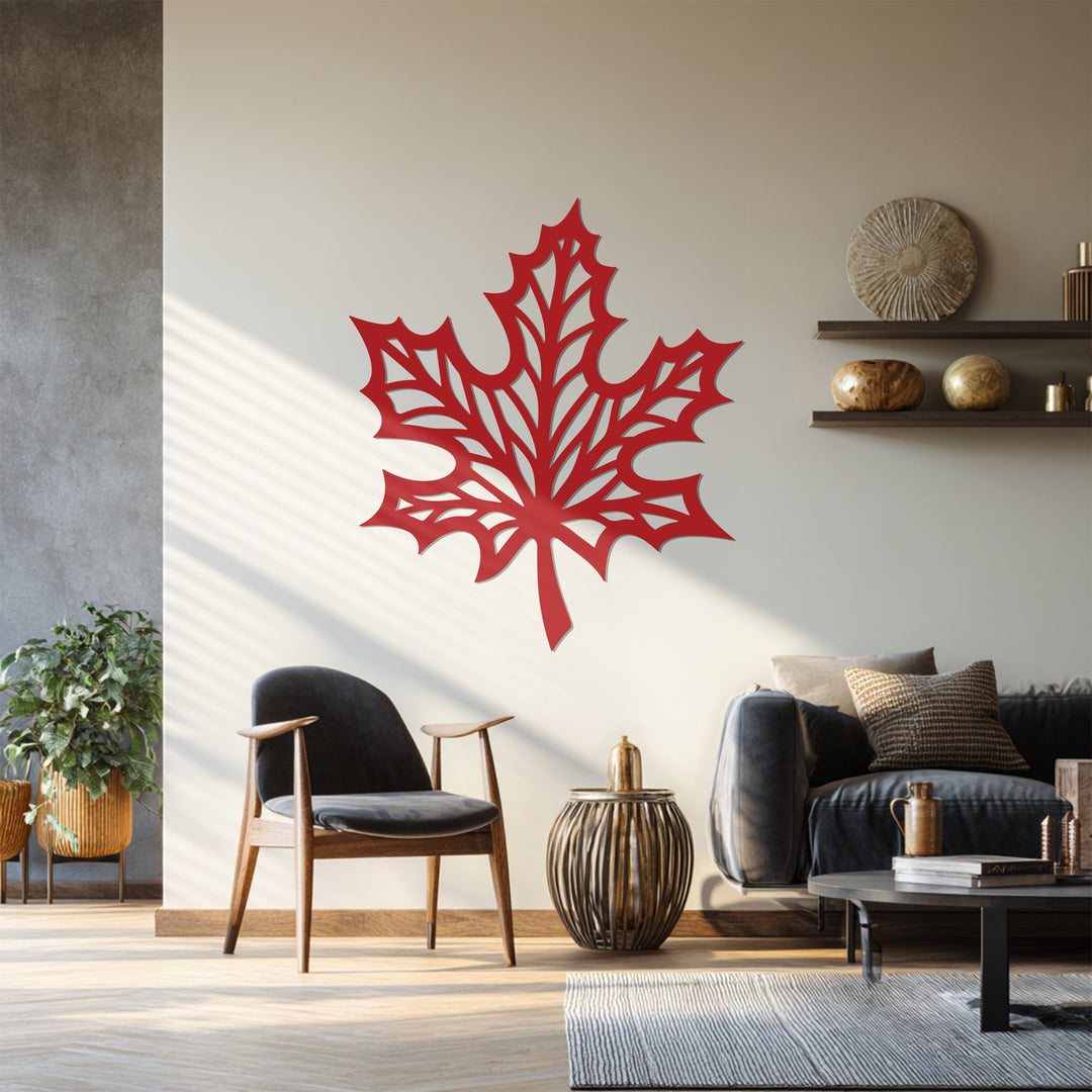 Shadows deepen the decorative metal art's etched design of this maple leaf, a striking wall accent bringing nature indoors.
