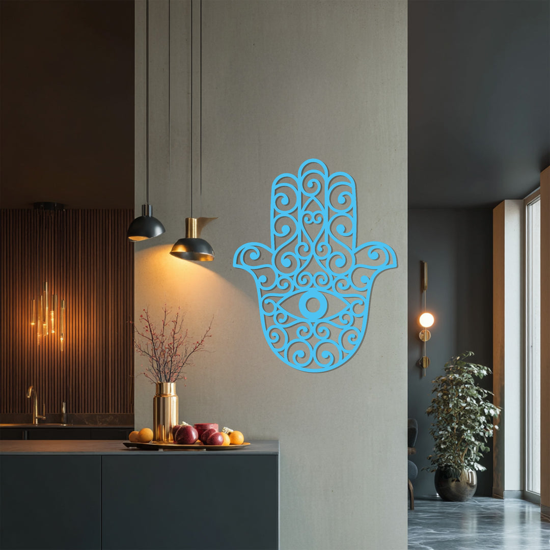 The light gray wall behind the blue Hamsa hand metal wall decor contrasts beautifully with the dark accents in the kitchen, showcasing a smooth color transition.