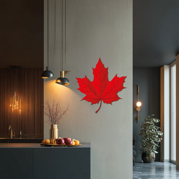 Shadowy recess highlights the intricate laser-cut details of this red maple leaf, a modern metal artwork adding a touch of Canadian nature-inspired home decor.