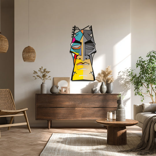 Light and shadow define the abstract tribal face in this unique metal wall art, highlighting its colorful, geometric form and modern, decorative presence.