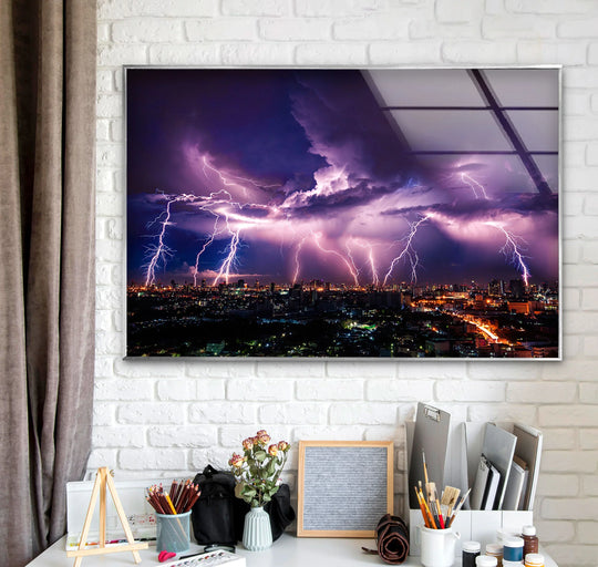 Framed with a sleek, silver edge, this Purple Lightning Storm over Cityscape glass wall art exemplifies unique modern wall decor, enhancing the dramatic night sky scene.