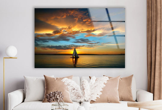 Vibrant, colorful clouds dominate the background sky in this golden hour sailboat sunset glass print, creating a stunning hanging wall art landscape.
