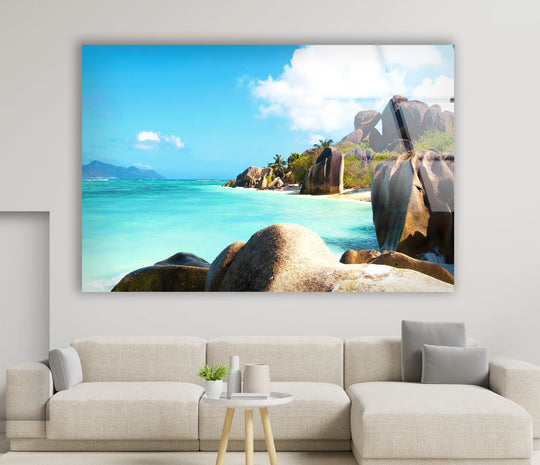 Central subject is the vibrant tropical granite beach captured in stunning detail in these glass wall prints, showcasing turquoise waters and majestic rock formations.