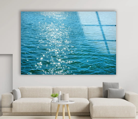 Showing depth and layers, the sunlit ocean surface is a captivating glass wall artwork, reflecting minimalist sea patterns with bright glimmers.