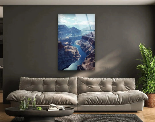 Foreground objects like a carafe, drinks, a book, and a round table accent the Grand Canyon Majesty glass wall art decor showcasing a breathtaking canyon landscape.