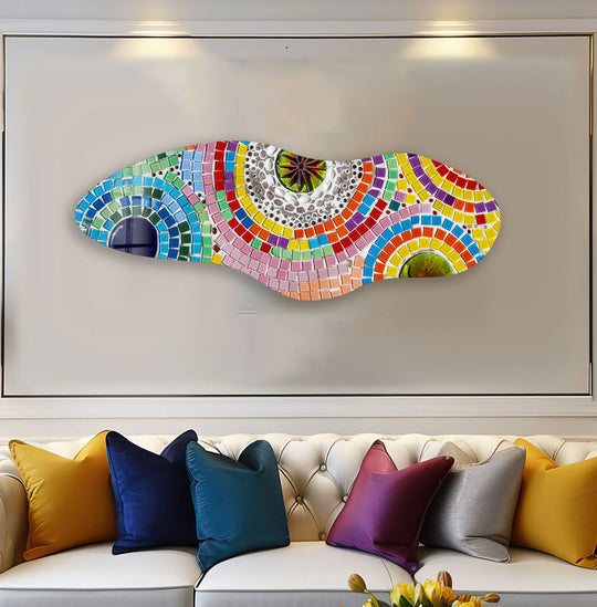 An asymmetrical pink mosaic glass wall art with bold color contrast and vibrant hues displayed on a light-colored wall.