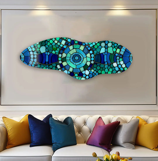 Negative space surrounds a vibrant mosaic of blue and green glass shards, a unique modern wall decor.