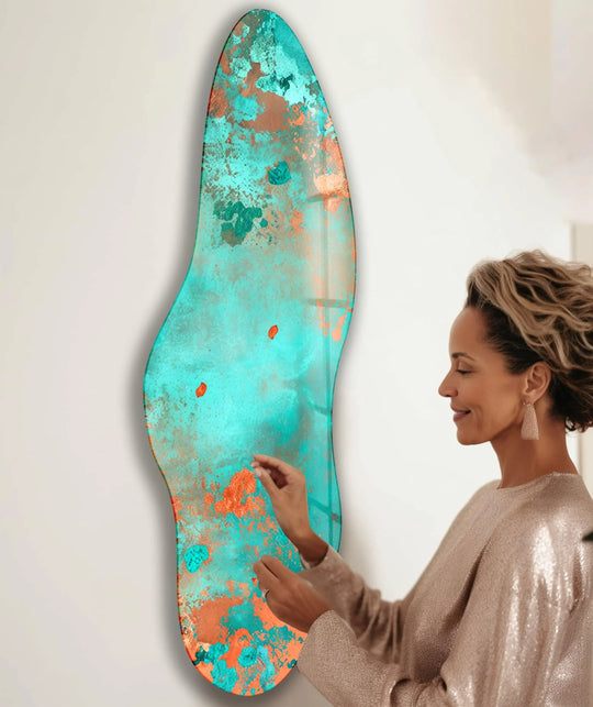 A woman admires an irregular asymmetrical abstract splash glass art piece with realistic turquoise and bronze details.