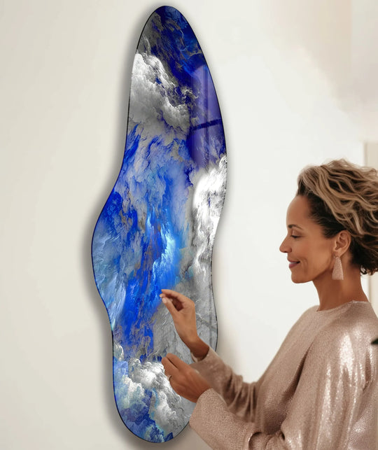 An irregularly shaped, asymmetrical glass wall art decor piece featuring a dynamic blend of navy blue and white cloud-like formations.