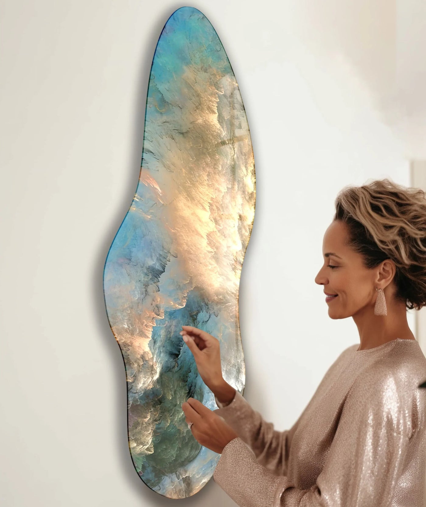 A woman admires an irregular asymmetrical glass art painting with cool blue and warm golden hues, showcasing a striking color temperature.