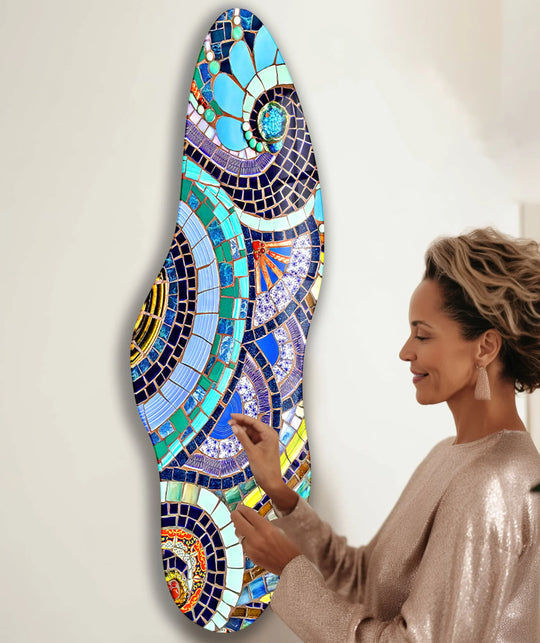 A woman admires a vibrantly colored asymmetrical glass printing that stands out against a plain white background.