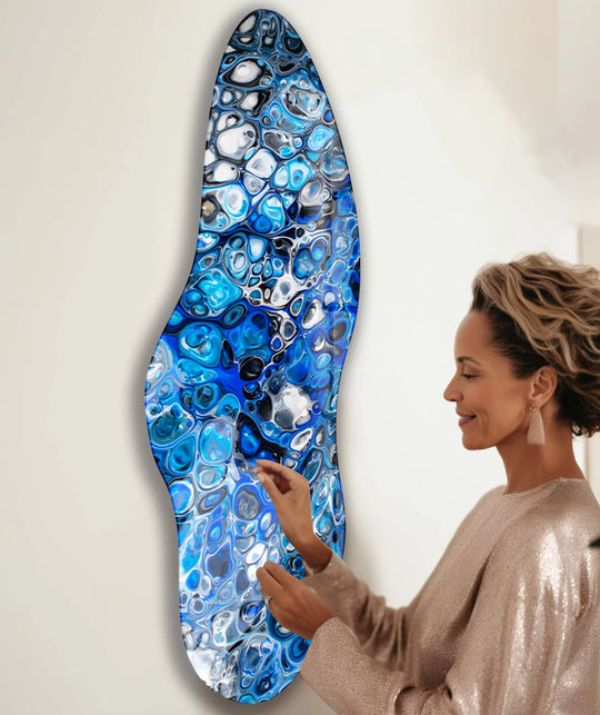 A woman admires a detailed navy blue watercolor irregular glass printing with fluid, abstract organic shapes.