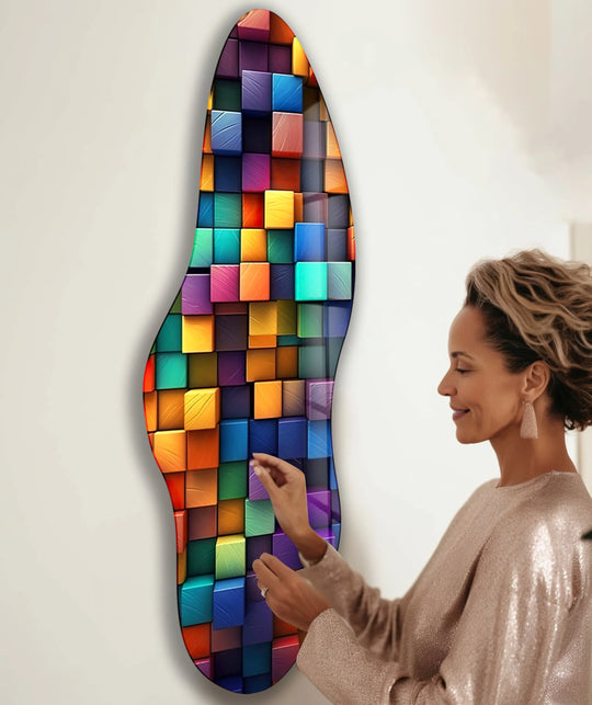 A woman admires a vibrant pop art abstract glass wall art, showcasing the brightest areas of colorful cubes.