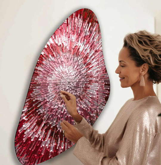 A woman admires asymmetrical abstract decorative wall art with radiating red and white lines.