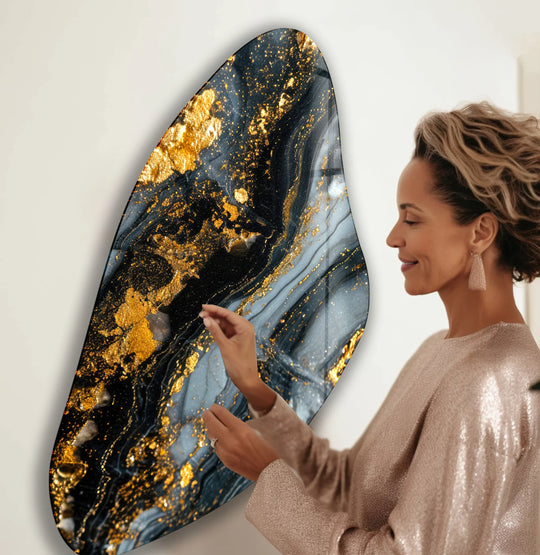 A woman admires the organic forms and golden flecks within this swirling alcohol ink glass wall art.