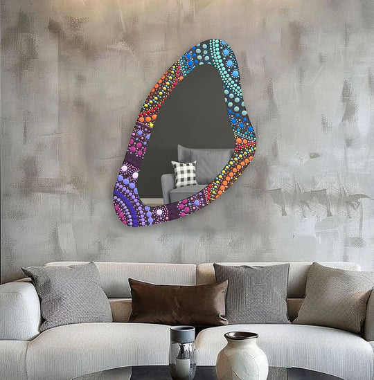 Negative space surrounds this colorful mosaic asymmetrical wall mirror, highlighting its unique shape and decorative mirror design.
