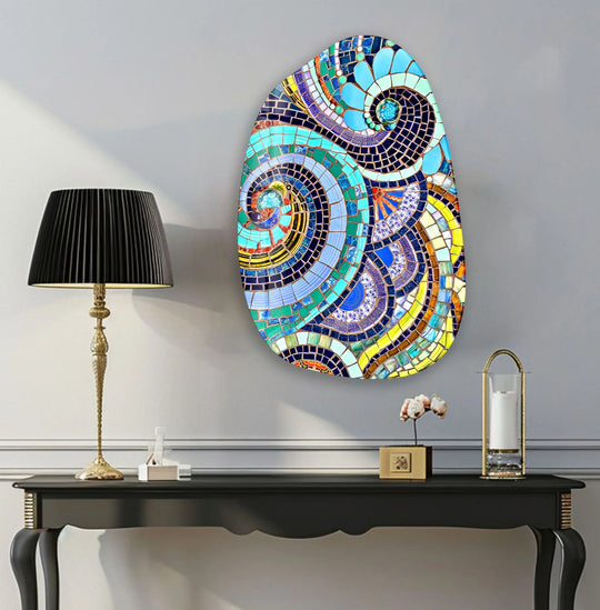 An abstract oval glass wall art explodes with swirling sapphire blues, emerald greens, and sunny yellows in a vibrant mosaic pattern.